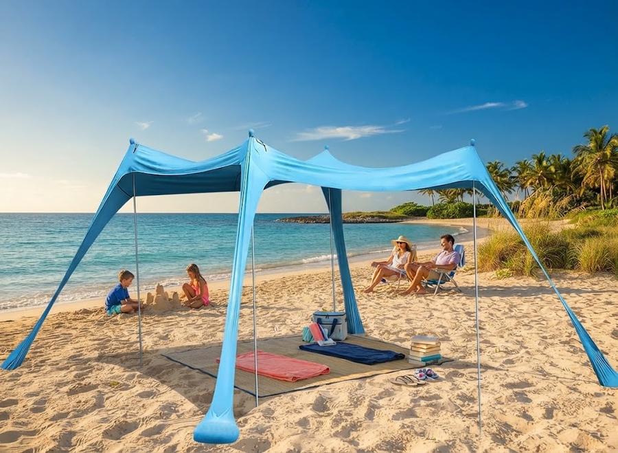 Turquoise beach canopy casting shade across towels and chairs at midday